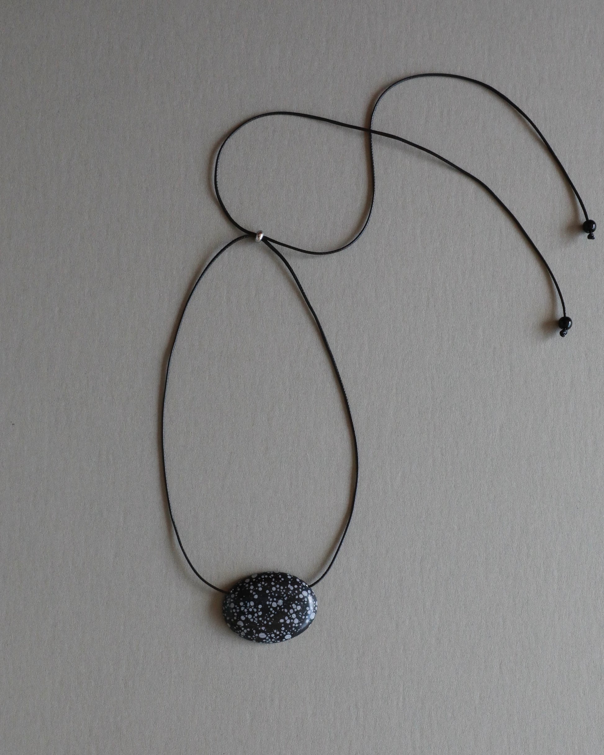 Super long snowflake obsidian pendant necklace with natural black and white speckled stone on adjustable black wax rope cord