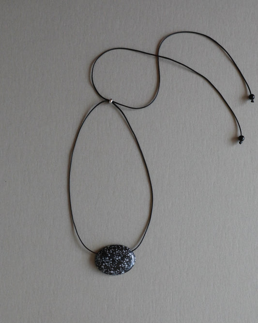 Super long snowflake obsidian pendant necklace with natural black and white speckled stone on adjustable black wax rope cord