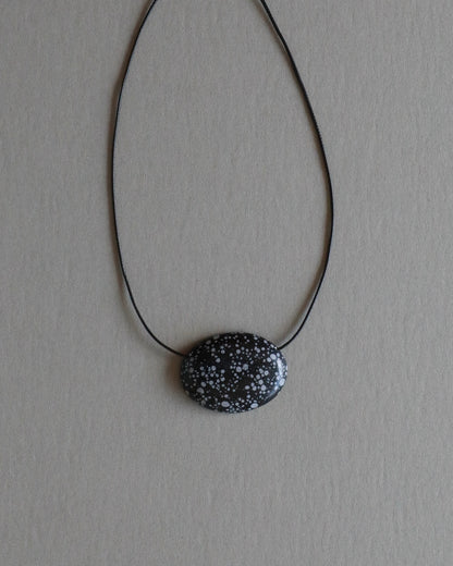 Super long snowflake obsidian pendant necklace with natural black and white speckled stone on adjustable black wax rope cord