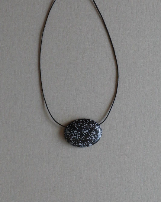 Super long snowflake obsidian pendant necklace with natural black and white speckled stone on adjustable black wax rope cord