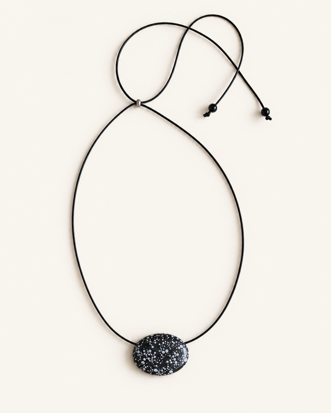 Super long snowflake obsidian pendant necklace with natural black and white speckled stone on adjustable black wax rope cord