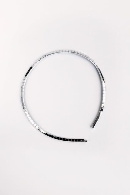 Flatlay of fluid sterling silver segmented necklace in circular shape on white background