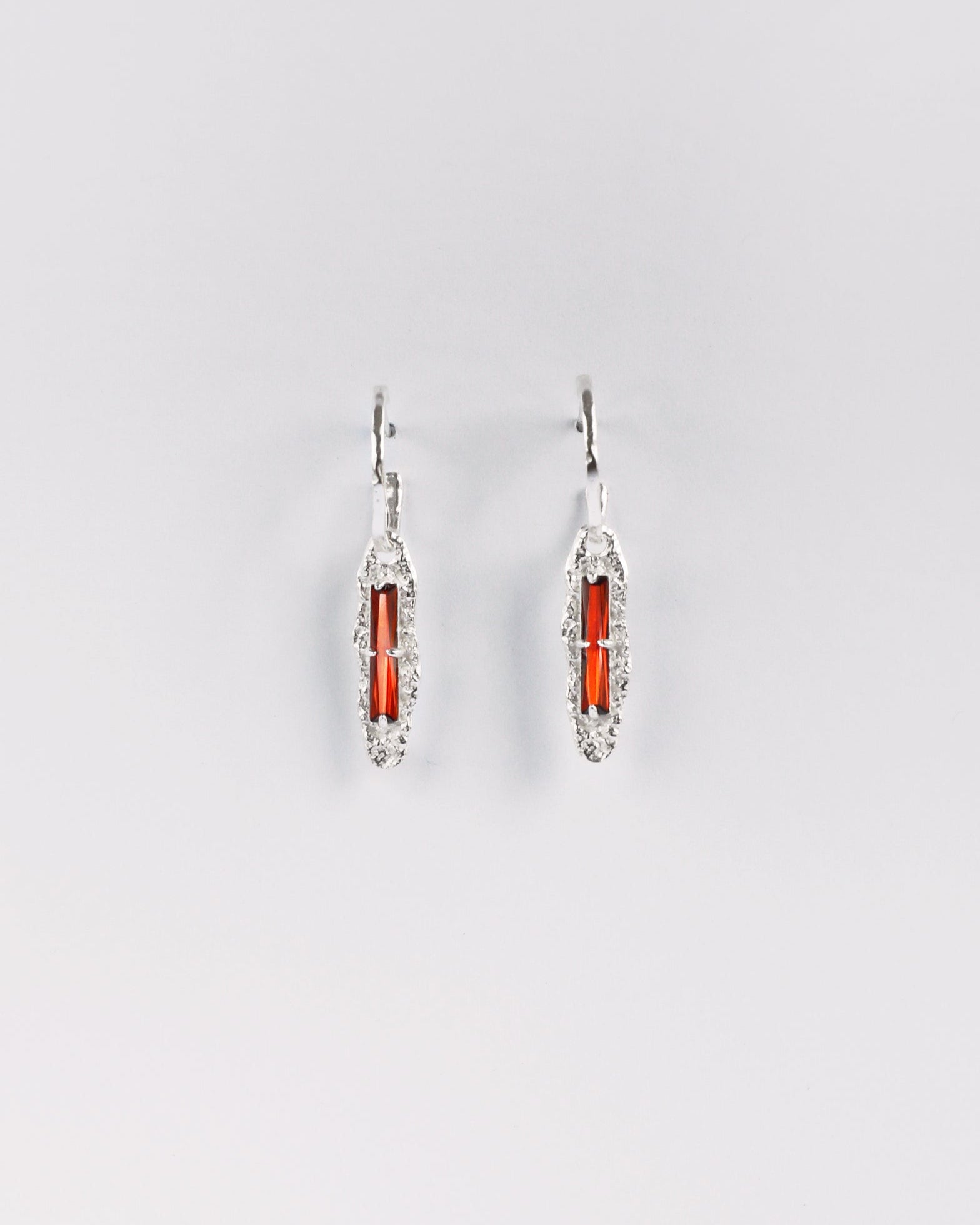 Sterling silver earrings with red cubic zirconia on white background