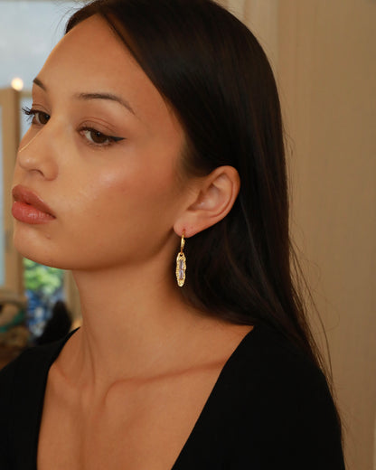 Twilight Gleam gold drop earrings with baguette-cut purple zircon stones, hammered organic pendants and polished gold hoops model
