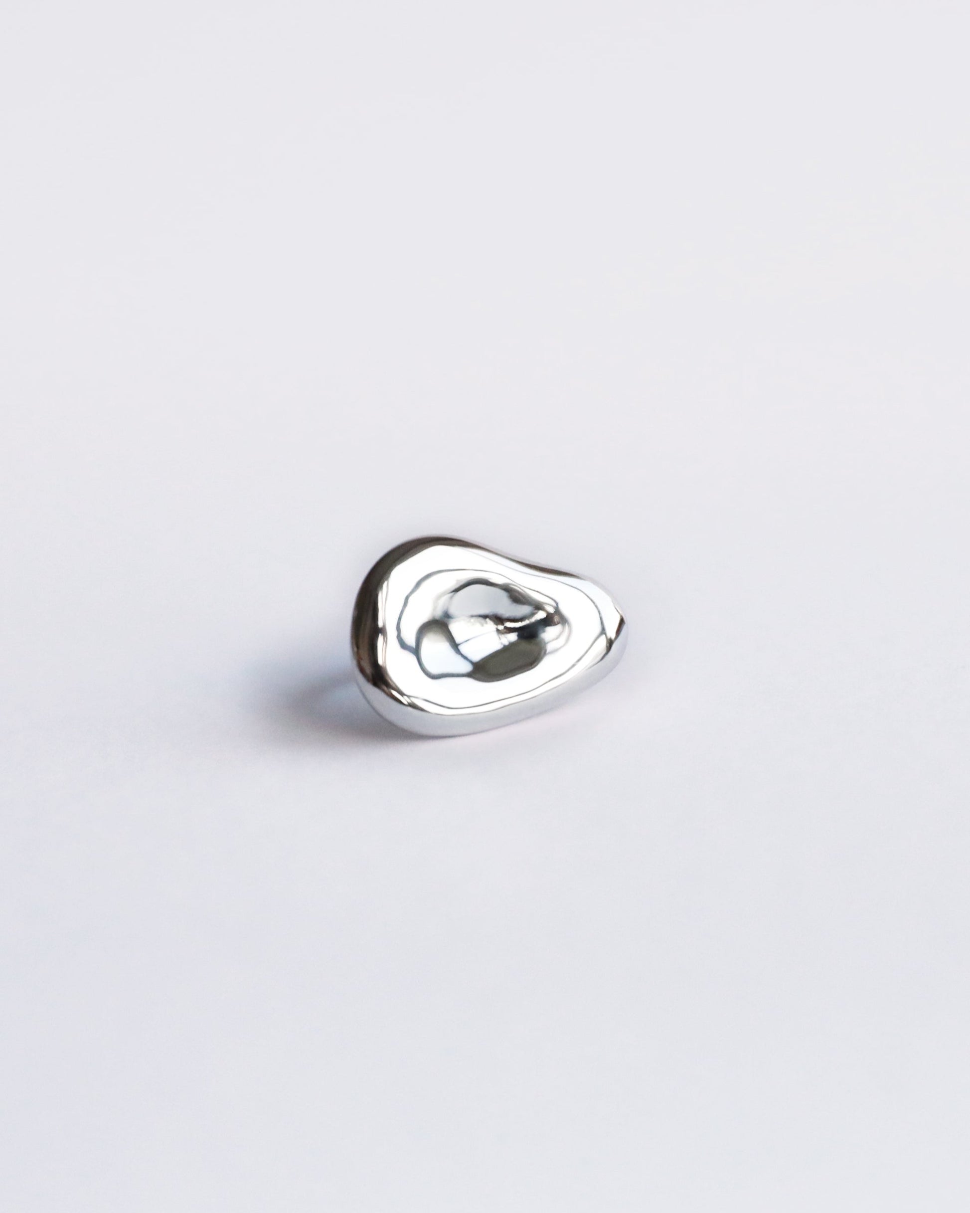 Centered product image of polished sterling silver sculptural ring with organic shape