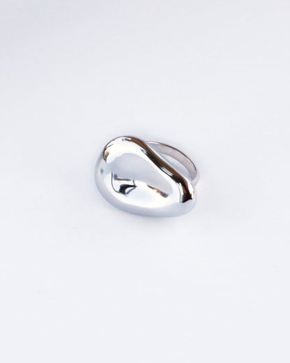 Minimalist studio shot of dome-shaped sculptural silver ring with smooth high-gloss finish