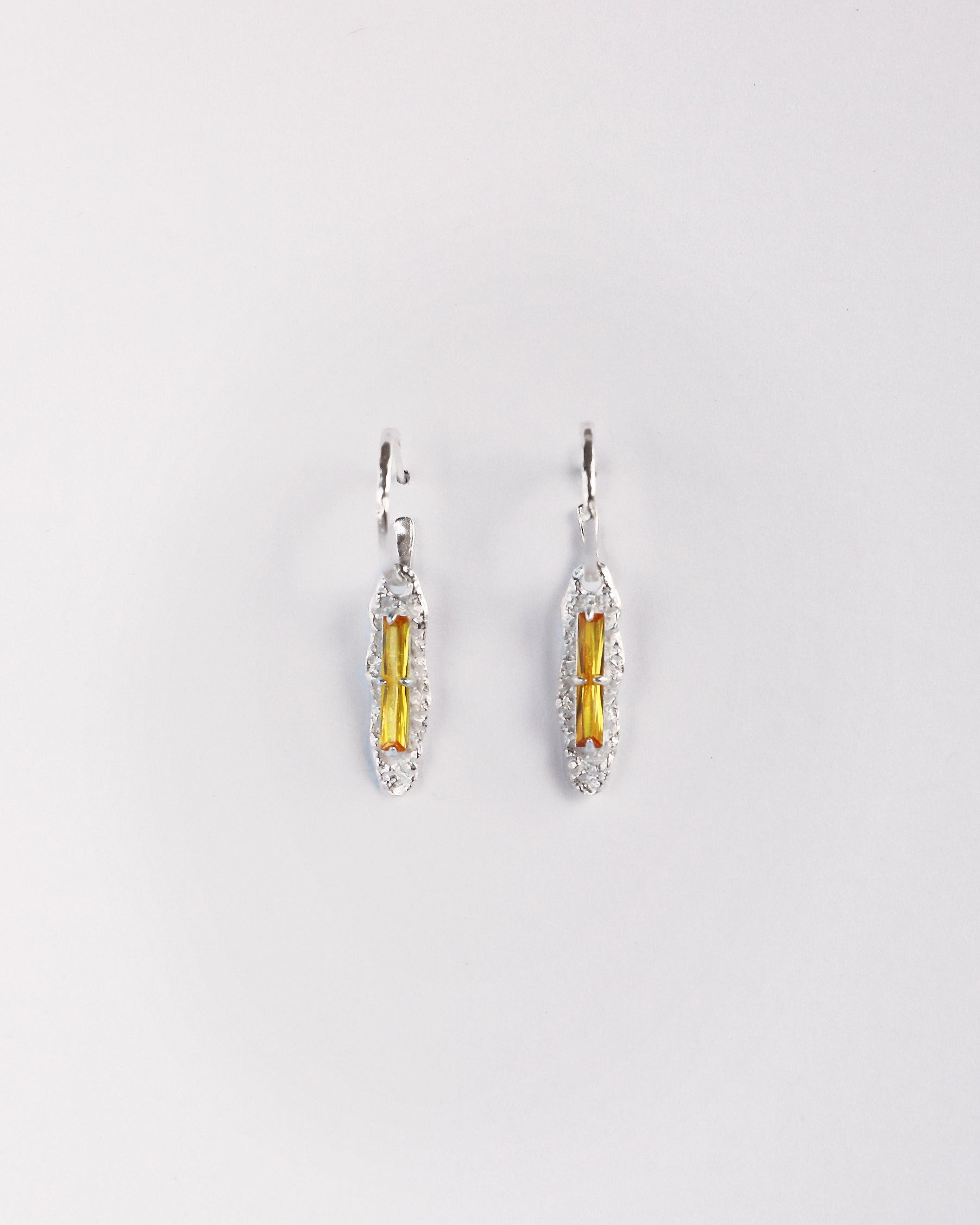 Front view of yellow zircon sterling silver drop earrings on white background
