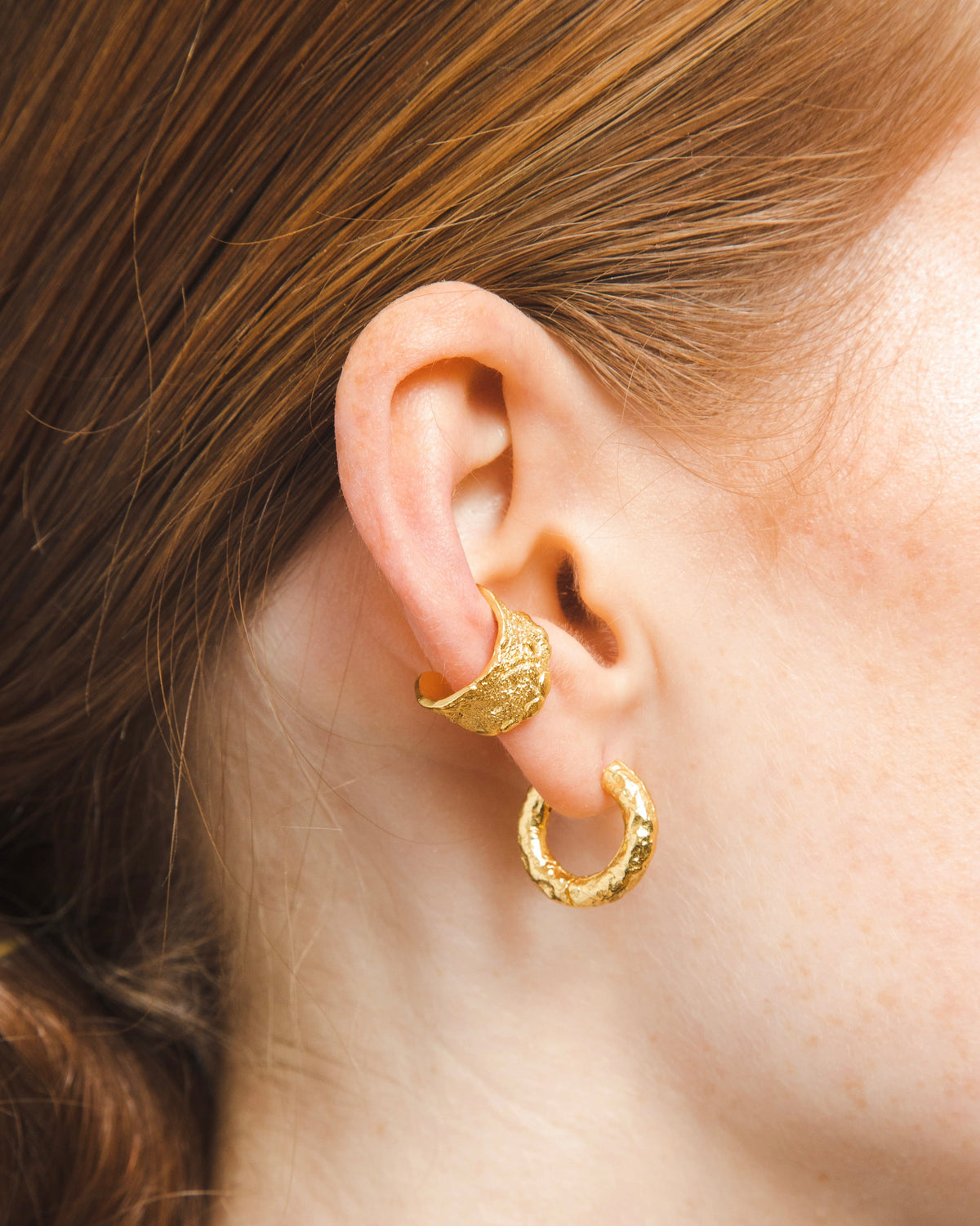 gold adjustable textured ear cuffs for non-pierced ears, nickel-free with an organic sculptural finish on model ear